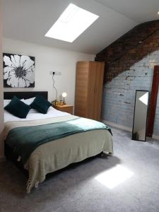 a bedroom with a large bed and a brick wall at Bliss Apartments - Contractor 314 in Bradford