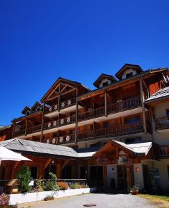 un grand immeuble d'appartements avec balcon et parasols dans l'établissement Le Cosy Mountain, aux Orres