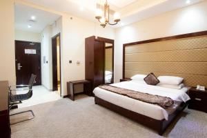 a bedroom with a large bed with a large headboard at Better Living Apartment in Dubai