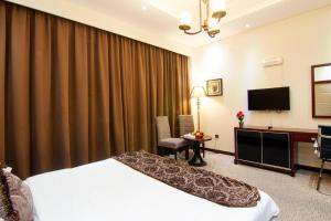 Cette chambre comprend un lit et une télévision à écran plat. dans l'établissement Better Living Apartment, à Dubaï