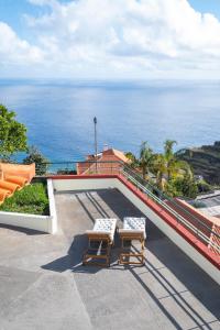 2 sillas en un balcón con el océano en el fondo en Casa Vista Mar by GALMI en Calheta