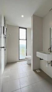 a white bathroom with a toilet and a sink at Spacious Townvilla - 10pax in Puchong
