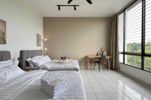 a white bedroom with a large bed and a desk at Spacious Townvilla - 10pax in Puchong