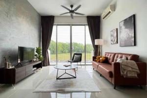 a living room with a brown couch and a tv at Spacious Townvilla - 10pax in Puchong