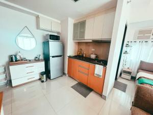 a kitchen with a refrigerator and a counter top at Studio Unit Viceroy Residences McKinley Hill BGC in Manila