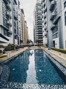 a swimming pool in a city with tall buildings at Studio Unit Viceroy Residences McKinley Hill BGC in Manila