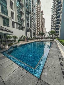 a large swimming pool in a city with tall buildings at Studio Unit Viceroy Residences McKinley Hill BGC in Manila