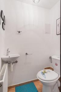 a white bathroom with a sink and a toilet at Bright Condo in Nusle by Prague Days in Prague