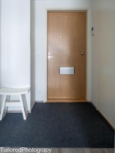 een lege kamer met een houten deur en een kruk bij Uusi asunto ydinkeskustassa, Wifi, ilmainen pysäköinti in Lappeenranta
