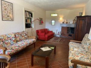 sala de estar con sofá y silla roja en Casa dell'emolo, en Clauzetto