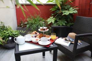 un vassoio di prodotti per la colazione su un tavolo nel patio di Hôtel Du Prince Eugène a Parigi