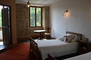 1 dormitorio con cama, mesa y ventana en DUC MANOIR Chambres d'hôtes, en Aubin
