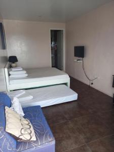 a room with two beds and a couch at Germaroze in Oslob