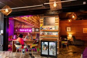 duas pessoas sentadas num bar num restaurante em The Nest Boutique Hostel em Galway