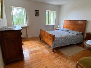 1 dormitorio con 1 cama grande y suelo de madera en Casa dell'emolo, en Clauzetto