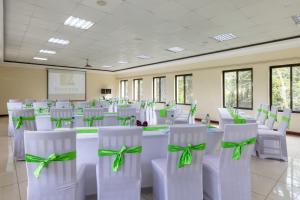 Zimmer mit weißen Stühlen und einem Tisch mit grünen Bogen in der Unterkunft Sentrim Elementaita Lodge in Elmenteita