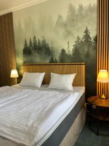 łóżko z dwoma poduszkami i obrazem na ścianie w obiekcie Penzion Kokorin Forest Villa w mieście Konrádov +37 zdjęć