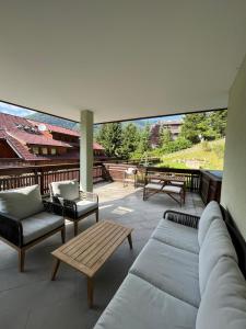 a patio with a couch and chairs and a table at 2 Bedroom Ski in Ski Out in Bach