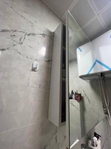 a bathroom with a shower and a white marble wall at Cozy apartment with great features in Antalya