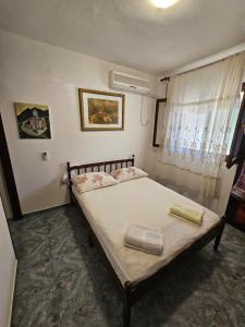 a bedroom with a large bed with a window at Apartman Antica in Komiža