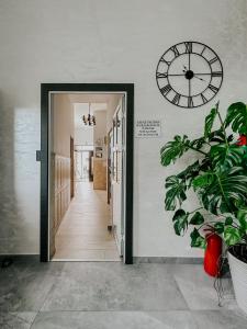a hallway with a clock on the wall and a plant at Willa Agnieszka in Jastrzębia Góra