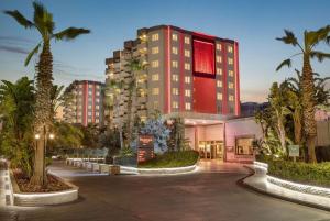 a hotel with palm trees in front of a building at Ramada Resort By Wyndham Lara in Lara