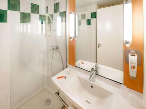 y baño con lavabo, ducha y espejo. en ibis Vannes, en Vannes