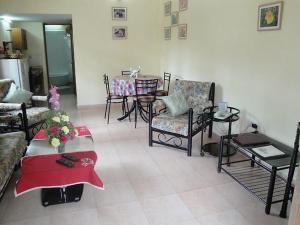 a living room with a couch and chairs and a table at Goa Garden Resort - Sandray Apartments & Villa at Benaulim - Colva beach in Colva