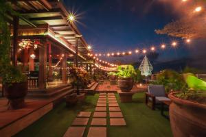 a patio at night with lights and potted plants at Swiss-Belinn Saripetojo Solo in Solo
