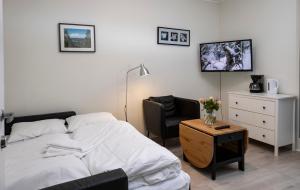 1 dormitorio con 1 cama, 1 silla y 1 mesa en Lillehammer Camping - Sentrums leilighet en Lillehammer