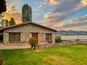 a stone house on the shore of a lake at The Little Stone House by the Lake in Kastoria