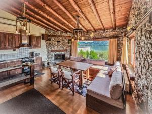 eine Küche und ein Wohnzimmer mit einem Tisch und einem Sofa in der Unterkunft The Little Stone House by the Lake in Kastoria