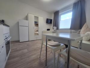 ein kleines Wohnzimmer mit einem Tisch und einer Küche in der Unterkunft Studio Apartment 17 - 2R2 in Essen