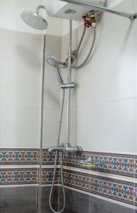 a shower in a bathroom with a shower head at FG Homestay, Kampala Muyenga-Bukasa in Kampala