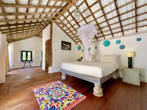 a bedroom with a bed and a wooden floor at Foozoo Mantra Weligama in Weligama