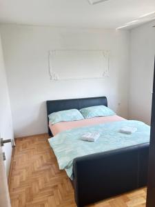 1 dormitorio con 1 cama con 2 toallas en Doboj Apartman, en Doboj