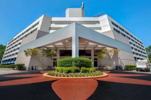 a large white building with a flower bed in front of it at DoubleTree Suites by Hilton Raleigh-Durham in Durham