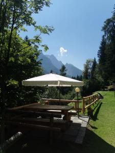 a picnic table with a large white umbrella at Val di Sole Holidays in Folgarida