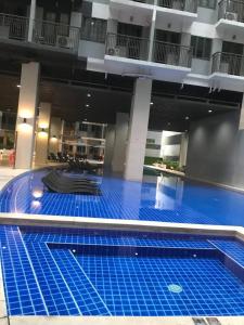 a large swimming pool in a building with blue tiles at LuxeRN Suite at S Residences in Manila