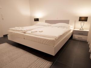 1 cama blanca grande en un dormitorio con alfombra en Ferienwohnung Seymen, en Eriskirch