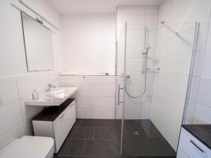 baño blanco con ducha y lavamanos en Ferienwohnung Seymen, en Eriskirch