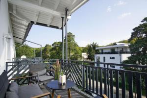 a balcony with chairs and a table on a balcony at schöne 2-Raum-Wohnung mit Balkon, gratis Nutzung vom AHOI Erlebnisbad und Sauna in Sellin - Villa Jolie FeWo 09 in Ostseebad Sellin