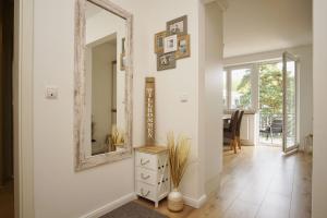 a hallway with a mirror and a dresser at schöne 2-Raum-Wohnung mit Balkon, gratis Nutzung vom AHOI Erlebnisbad und Sauna in Sellin - Villa Jolie FeWo 09 in Ostseebad Sellin +19 photos