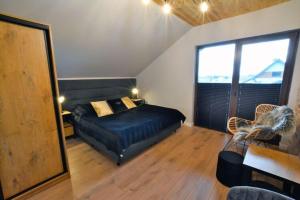 um quarto com uma cama e uma grande janela em Holiday house sauna whirlpool Mielenko em Mielenko