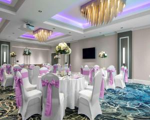 a banquet room with white tables and chairs and a chandelier at Hyatt Place Allentown - Lehigh Valley in Allentown