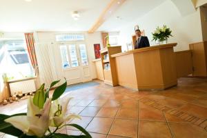 a man standing at a podium in a room at Flair Hotel Rieckmann in Bispingen