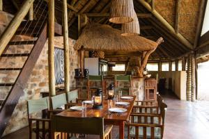 uma sala de jantar com uma mesa de madeira e cadeiras em Bushwa Private Game Lodge em Vaalwater