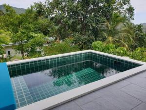 una piscina con tegole verdi sul tetto di The Love Nest - Stylish One Bed House a Ban Chalok Lam