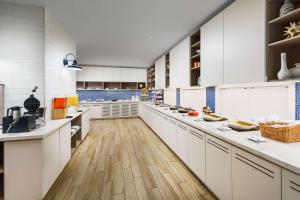 uma grande cozinha com armários brancos e pisos de madeira em Hyatt Place Panama City Beach - Beachfront em Panama City Beach