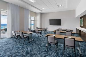 d'une salle de conférence avec des tables et des chaises et une télévision à écran plat. dans l'établissement Hyatt Place Panama City Beach - Beachfront, à Panama City Beach